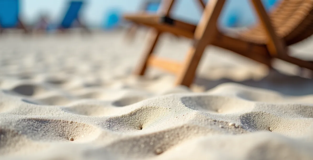 Nahaufnahme von feinem weißen Ostseesand mit Strandkorb und Qualitätssiegel